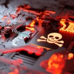 Skull & crossbones embedded in a computer motherboard glowing red